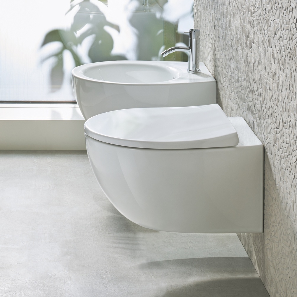 Lifestyle image of the Catalano Italy 52 Wall-Hung Rimless Toilet mounted on a toilet wall, next to a bidet